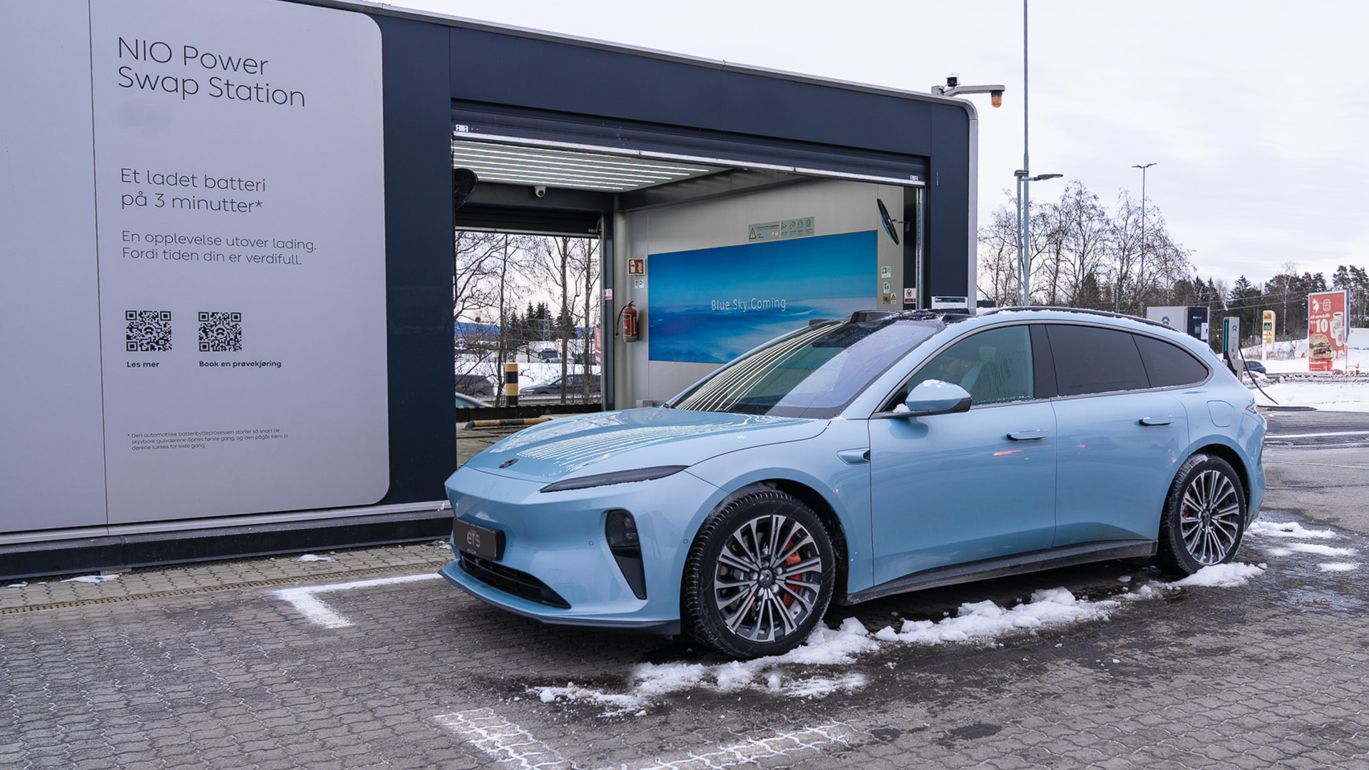 Batteribyttestasjonen p&aring; Kl&oslash;fta, der en ET5 Touring klargj&oslash;res for batteribytte ved &aring; fjerne sn&oslash; og is b&aring;de over og under bilen.